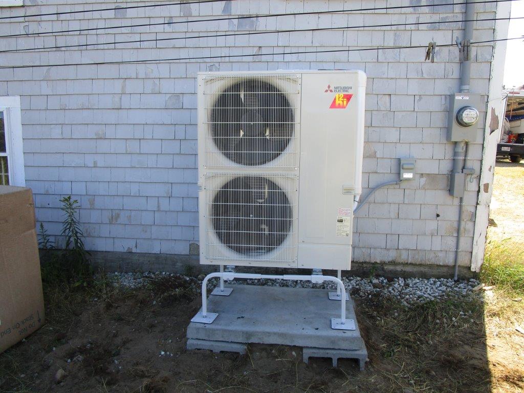 Outdoor installation of Mitsubishi Hyper-Heating heat pump condenser unit.