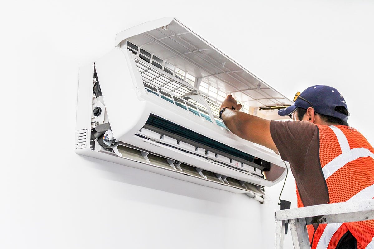 AC technician cleaning out ductless air conditioner 