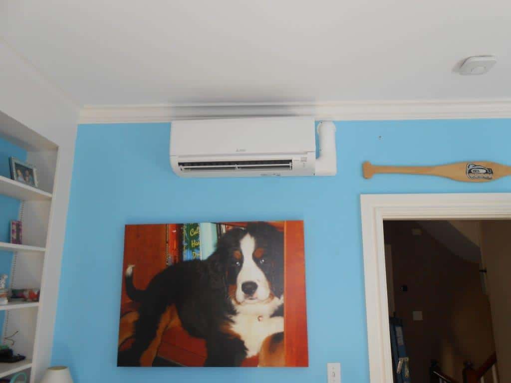 Indoor installation of ductless heating and air conditioning in living room.