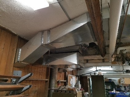 Example of custom ductwork build around old steam piping for central AC.