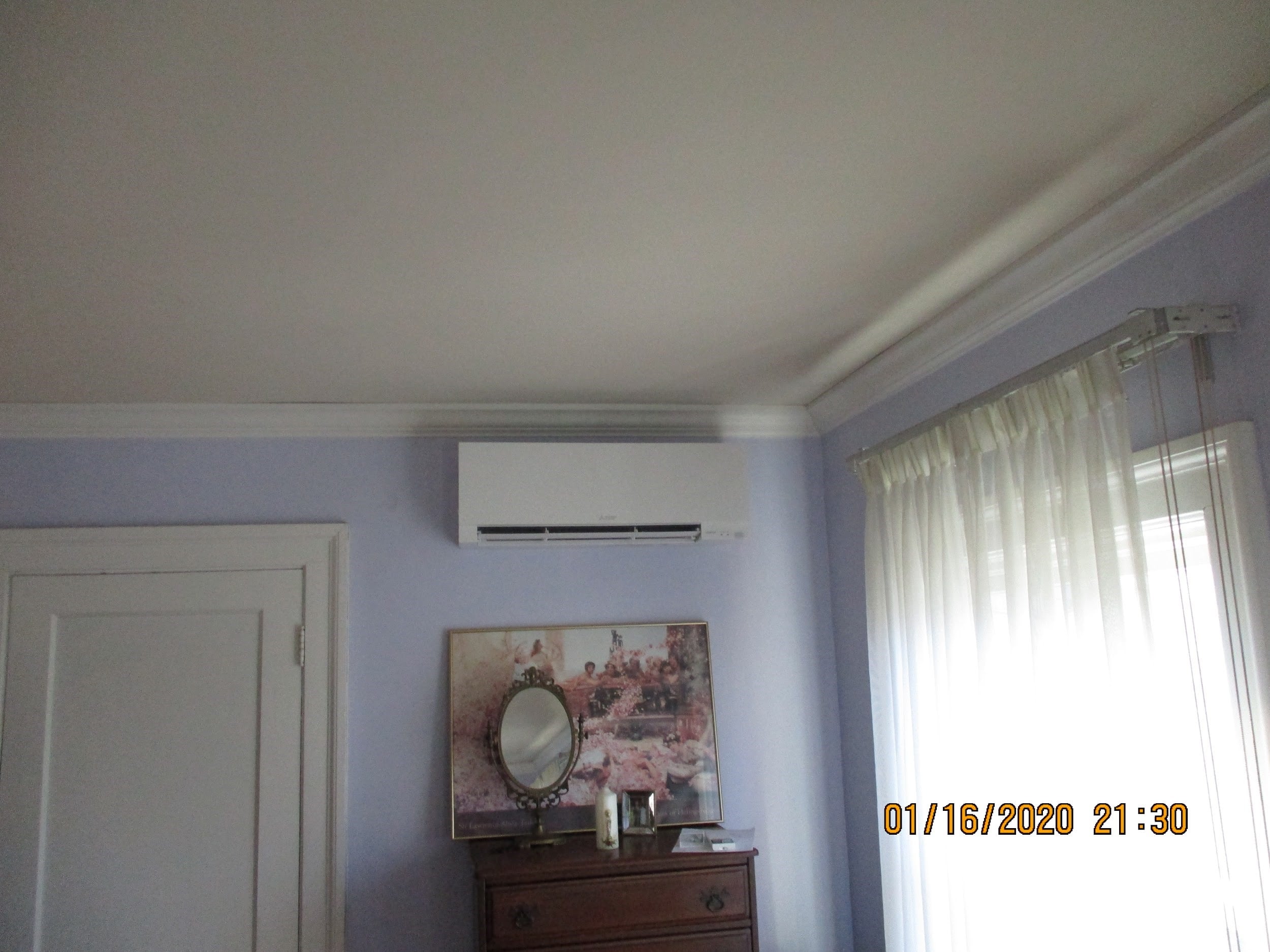 Indoor Mitsubishi ductless AC installed in a bedroom. 