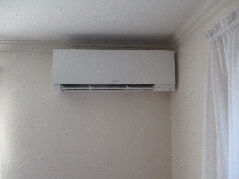 Indoor installation of Mitsubishi ductless Hyper-Heating heat pump unit.