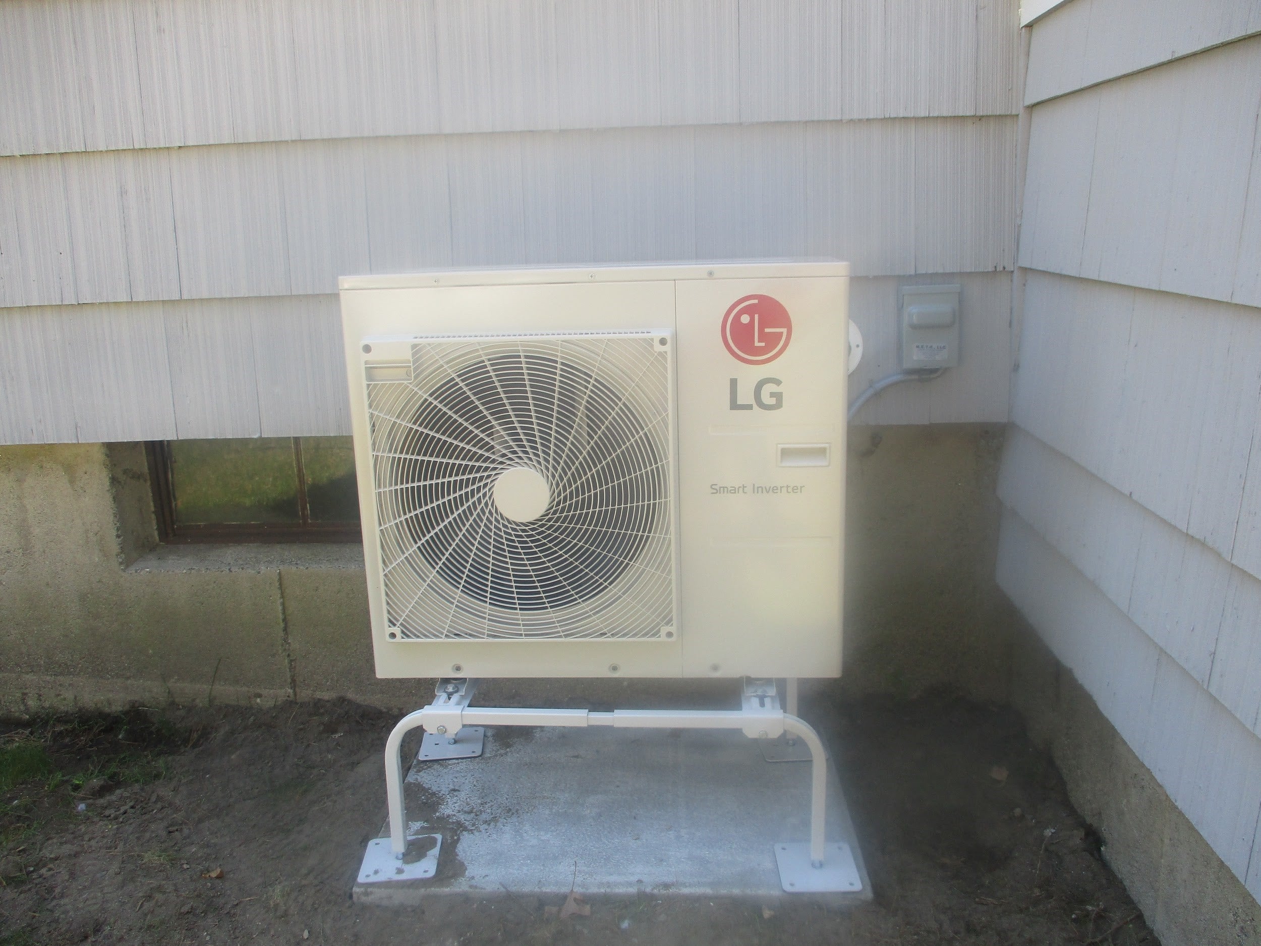 LG ductless outdoor condenser unit and heat pump outside Tewksbury home.