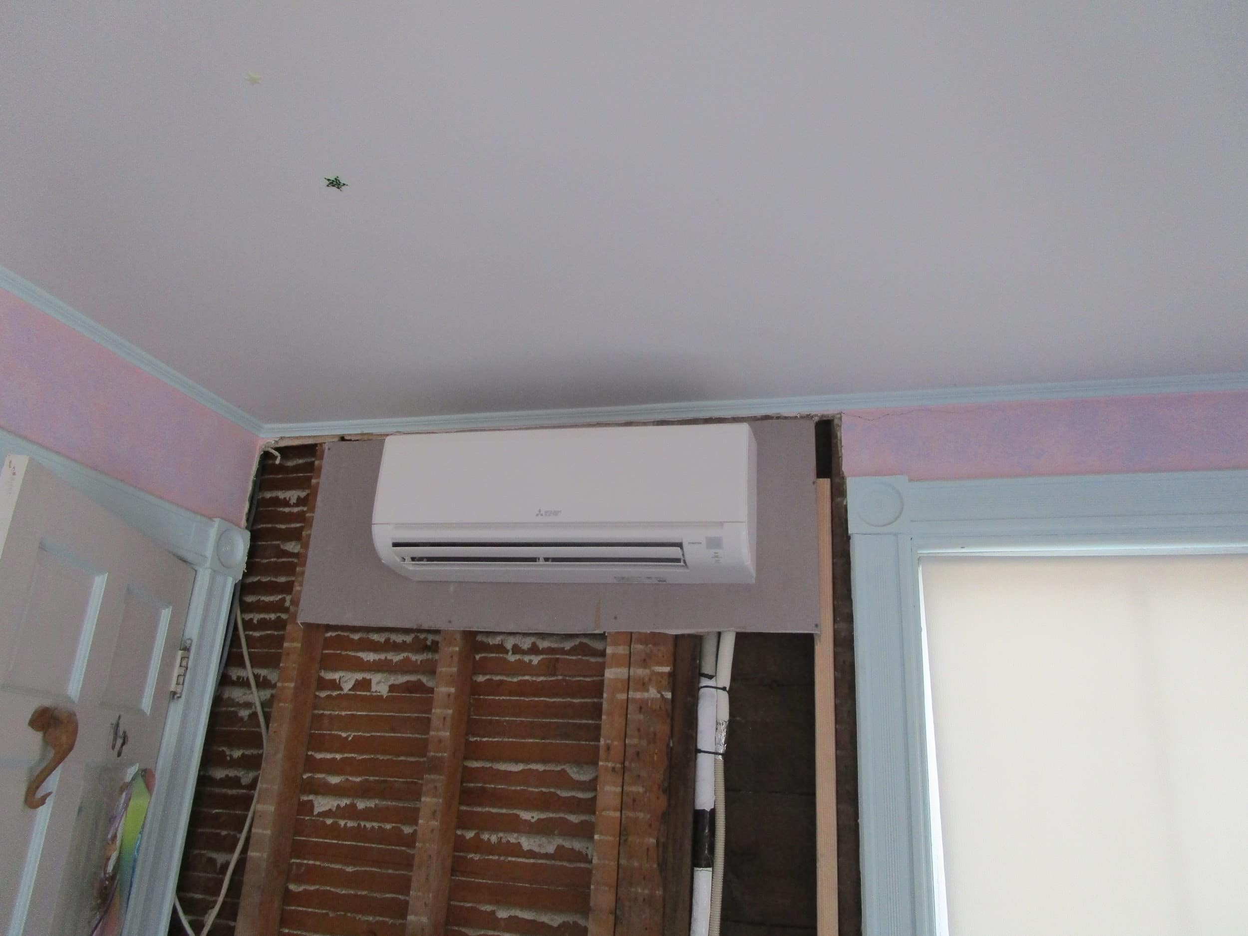 Indoor installation of Mitsubishi ductless AC wall unit.