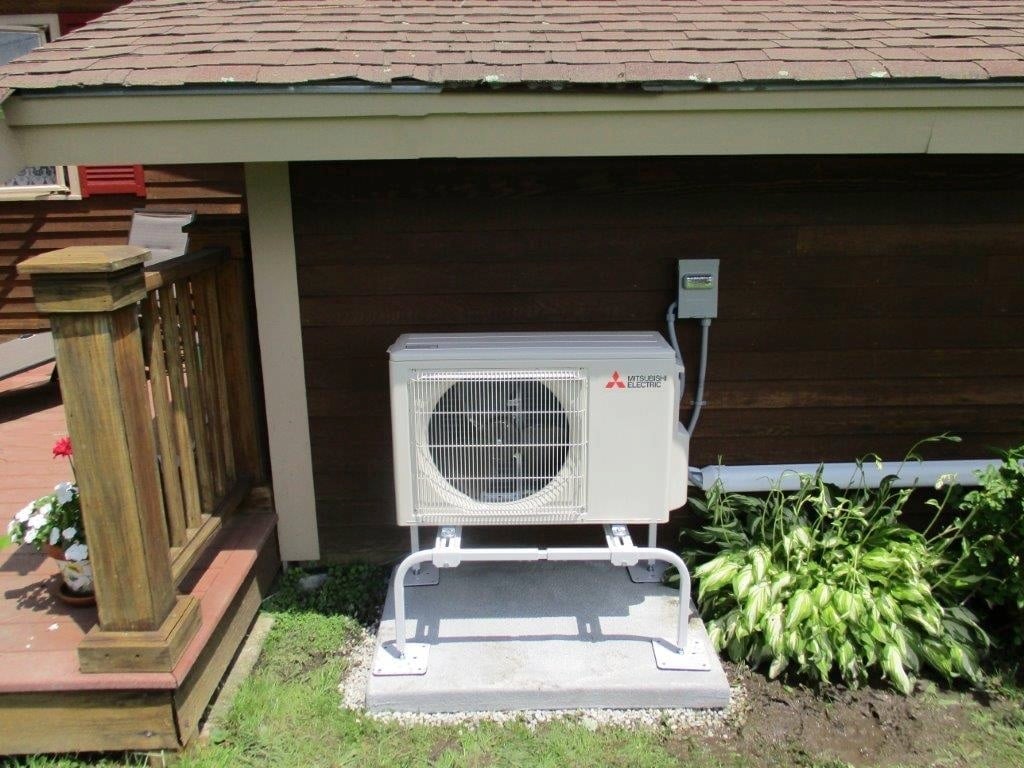 Outdoor installation of Mitsubishi Ductless Hyper-Heating heat pump and air conditioning condenser unit.