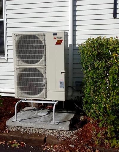 Example of an outdoor Mitsubishi Hyper-Heating ductless heat pump condenser installation.