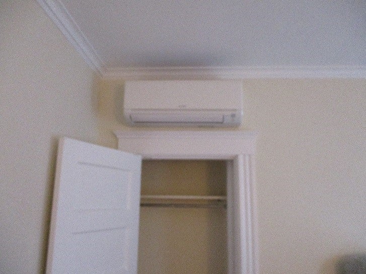 Indoor installation of ductless heating and cooling unit in Cambridge multi-family home.