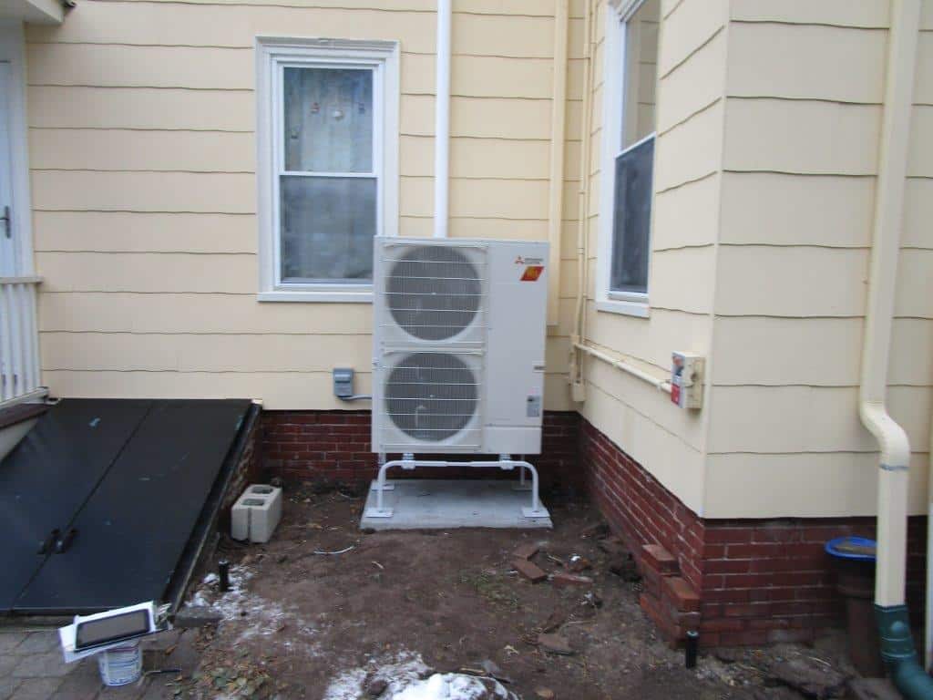 Outdoor installation of Mitsubishi ductless heat pump in Somerville.