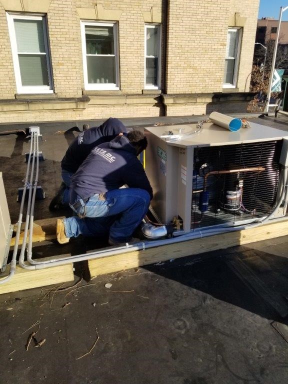 Installing outdoor refrigeration condensers on the roof of a store, Cambridge, MA