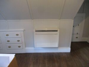 A floor-mounted Mitsubishi ductless AC installed in a bedroom in Swampscott home.