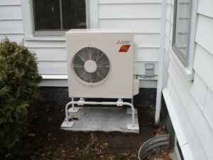 An outdoor air handler heat pump installed outside Boston two-family home.