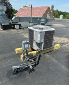Outdoor Carrier condenser on roof of Parish School for Mitsubishi ductless HVAC system.
