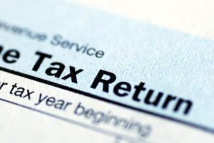 Close-up of a U.S. tax return form showing the text "Tax Return" in bold letters on a blue and white document.