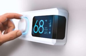 A hand adjusts a digital thermostat set to 68°F, displaying mode, eco setting, and outside temperature of 23°F.