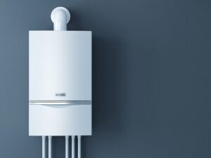 A white gas boiler mounted on a blue wall with several pipes connected at the bottom and a vent pipe extending upward.